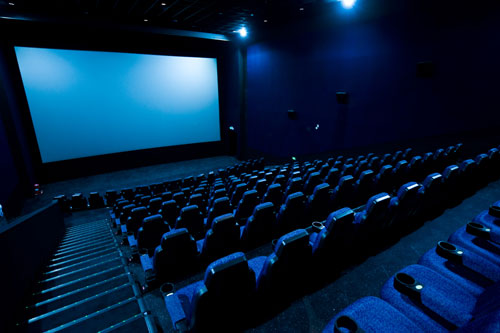 Dark movie theatre interior. Screen, seats.
