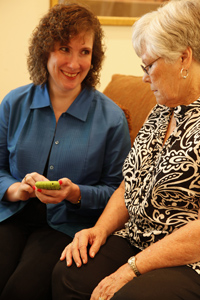 woman showing small electronic device to another woman