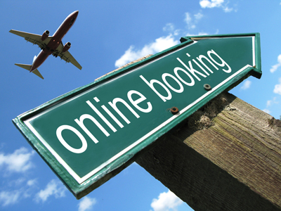 'Online Booking' road sign with an airplane overhead in the background.