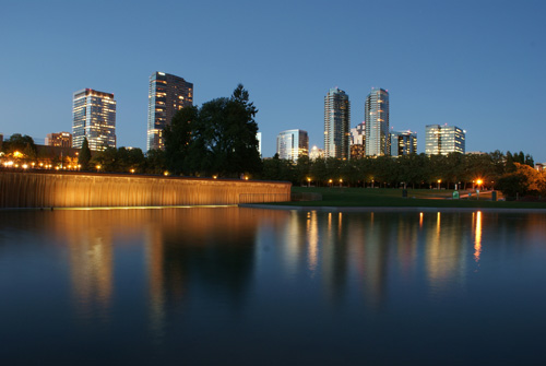 Illuminated skyline of Bellevue, Washington at twilight reflected in a pool at Downtown Park.