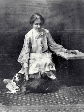 Helen with her Boston Terrier, reading a braille book, 1904