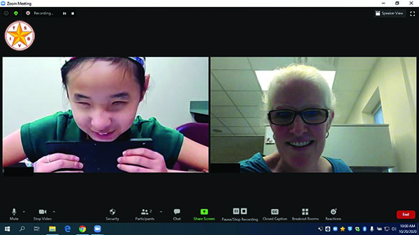 An Asian middle school girl and her White TVI meet in Zoom for a math lesson. The student has her abacus in her hands. Both have broad smiles on their faces. 