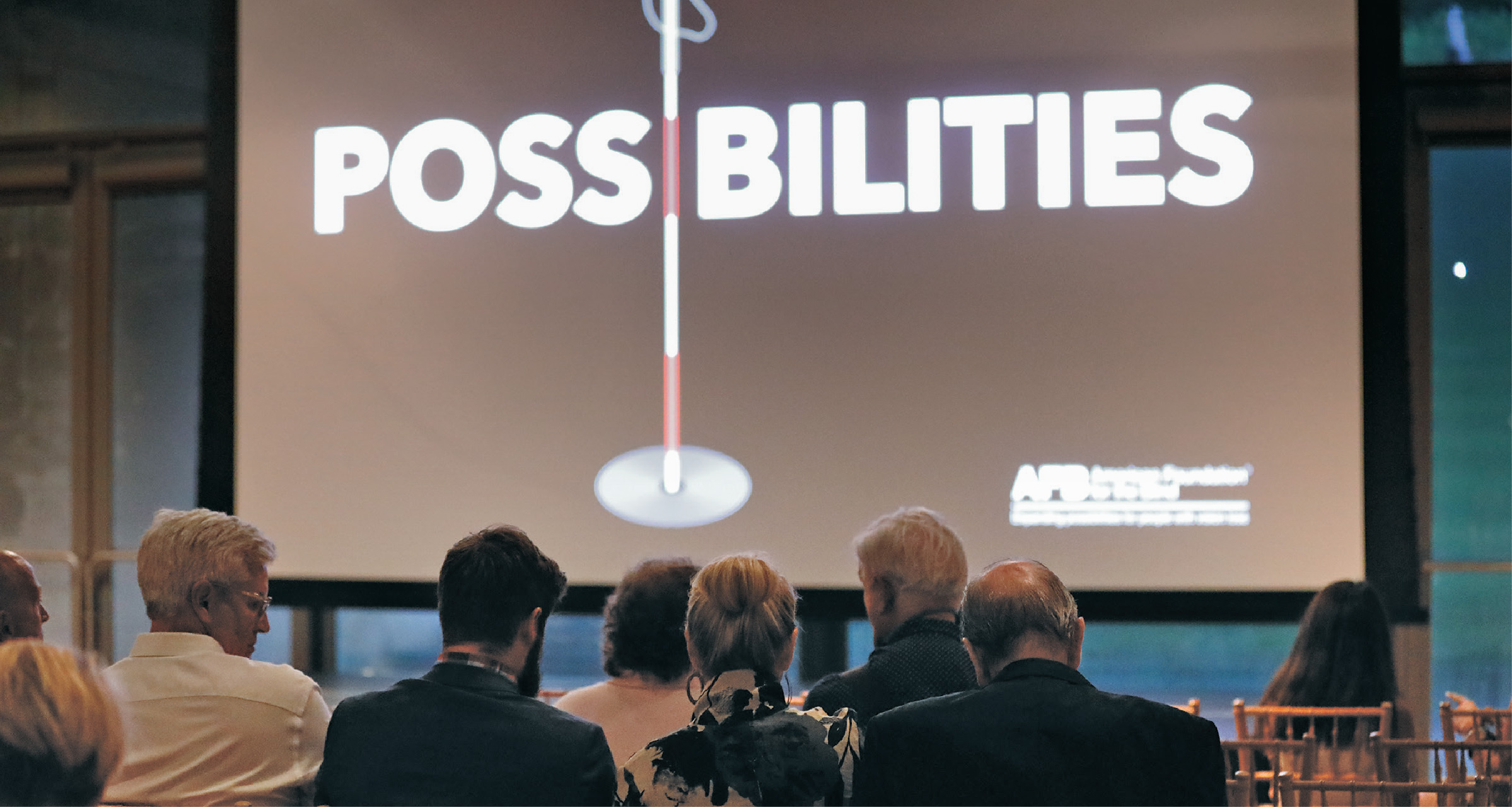 Audience members looking at a screen with the "Possibilities" documentary logo.