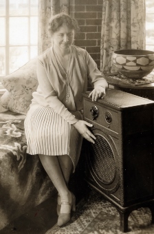 Photo of Helen Keller touching the front of a radio