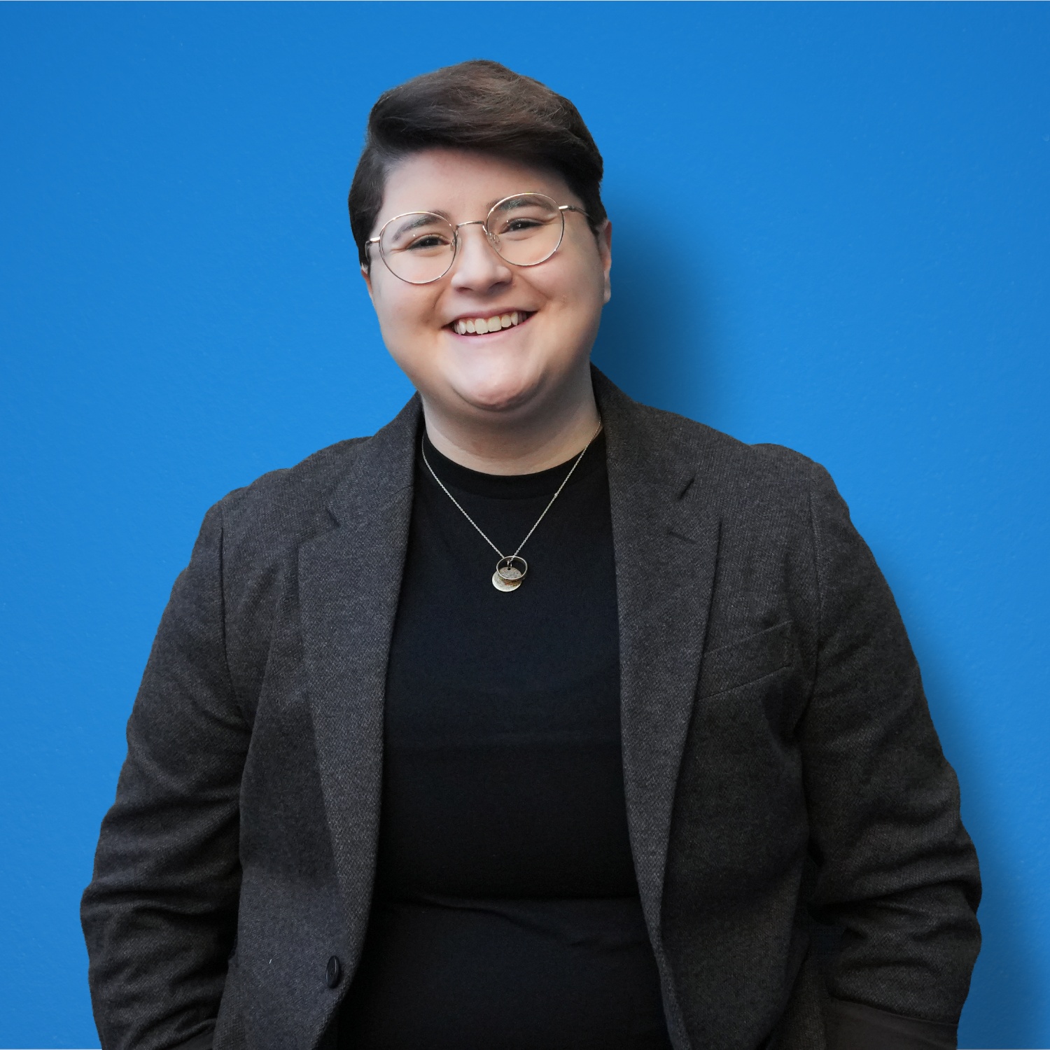Angie, a smiling woman with short brown hair and glasses.