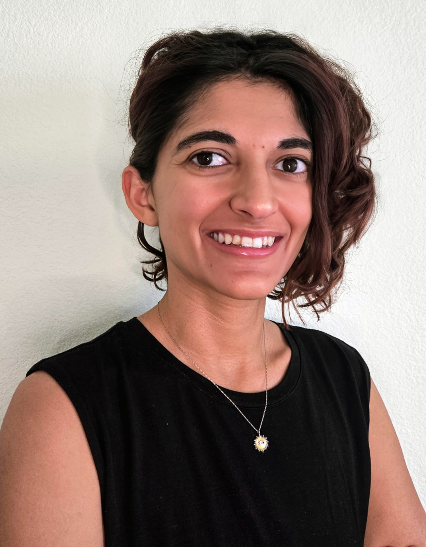 Carmel, a smiling woman with chin length, wavy brown hair.
