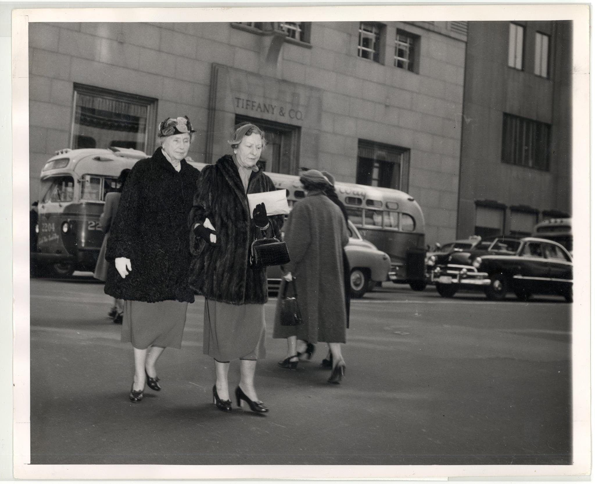 Helen Keller and Polly Thomson crossing the street in front of Tiffany and Co. store, 5th Avenue and 57th Street, New York City, circa 1956