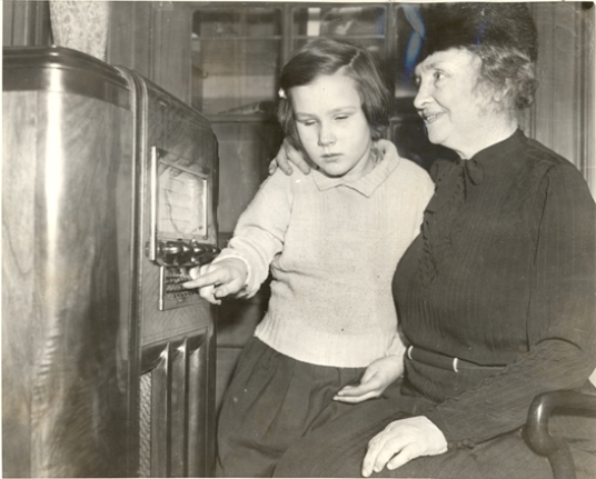 Helen with a little girl listening to the radio, 1938