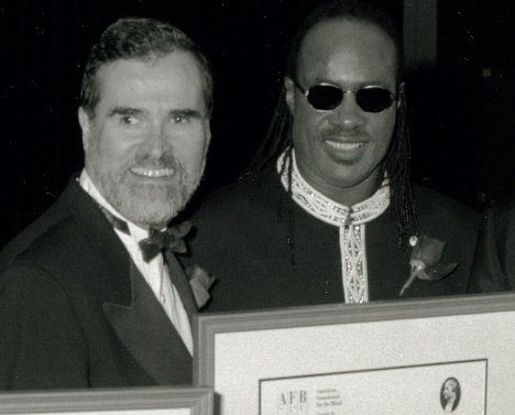 Carl Augusto presenting Stevie Wonder with the Helen Keller Achievement Award in 1996