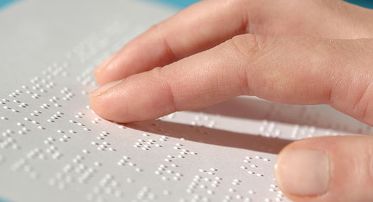 Hand moving over a text in braille