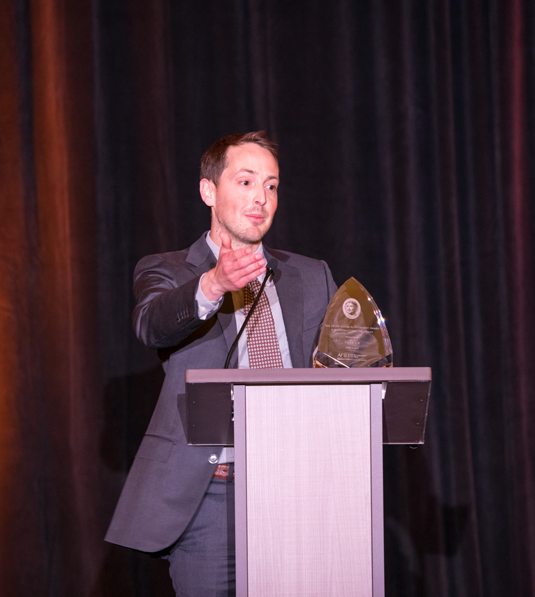 Jeff Wieland from Facebook stands at the podium with his HKAA award while addressing the audience