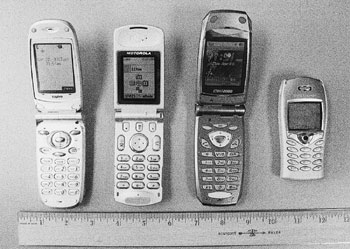 Figure 1: Photograph of four cellular telephones positioned along a ruler.