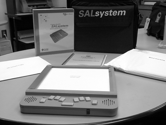 Figure 1: Photograph of SAL unit with touch screen and braille keyboard, manual, carrying case, and lessons.
