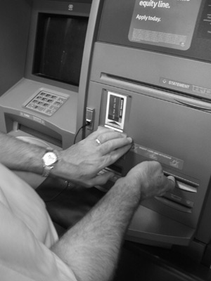 Figure 2: Close-up photograph of hands exploring the slots and braille labels on the Chase e-ATM.