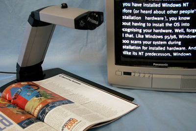 Figure 1: Photo of the Prisma focused on a magazine with the text appearing white on black on a television monitor.