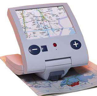 Photo of the Traveller sitting on a map, with an enlarged portion of the map displayed on the device's screen. Large controls, including buttons with a minus and a plus sign, appear below the screen.