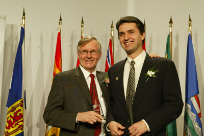 Photo of Lawrence Euteneier being congratulated by an unidentified gentleman.