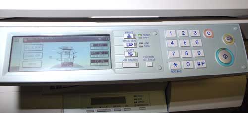 The control panel of the Imagistics copier, with the touch screen on the left and control buttons and number pad on the right.