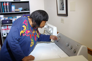 Photo of a woman turning the control knob on a dryer.