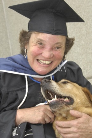 Photo of Jan in cap and gown with her dog guide.