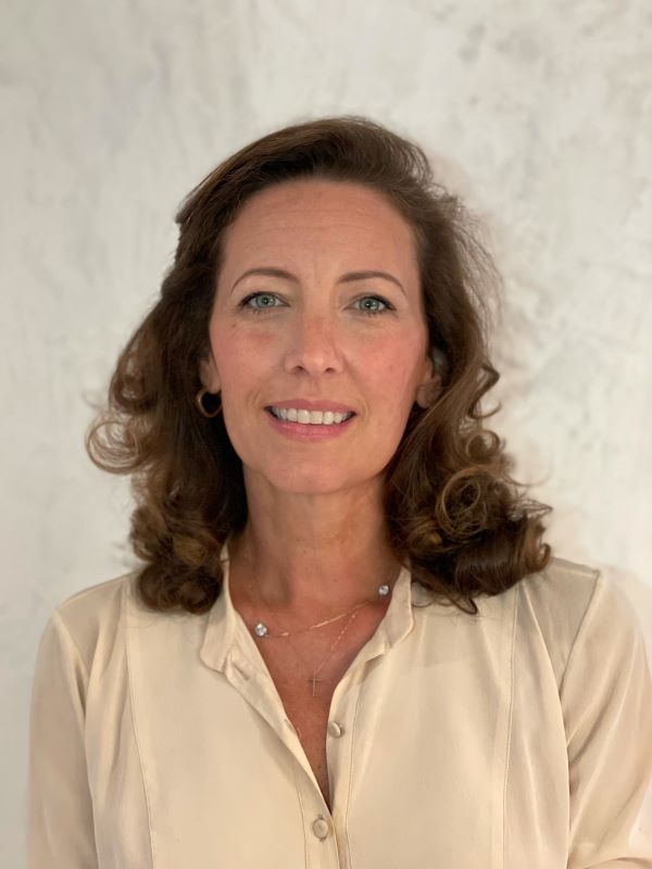 Headshot of Meredith Gale, a caucasian woman with long brown hair, wearing a white blouse.