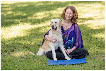 Woman with yellow lab guide dog, sitting outside on the grass